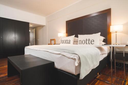 ein Hotelzimmer mit einem großen Bett und einem Tisch in der Unterkunft Hotel Tolosa in Puerto Madryn