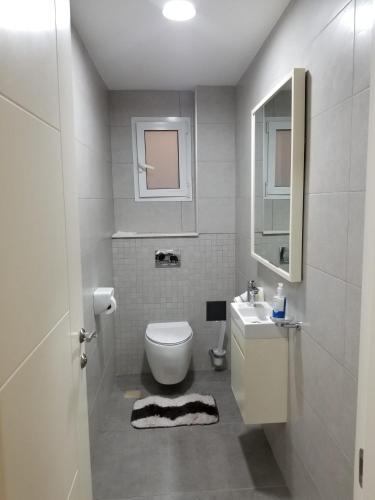 a white bathroom with a toilet and a sink at Escape to Eden Heights in Tokuse