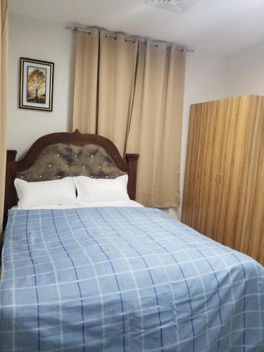 a bedroom with a blue blanket on a bed at Escape to Eden Heights in Tokuse