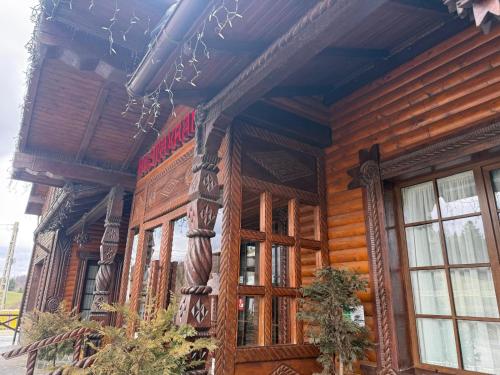 a wooden building with wooden doors and windows at HANUL TENTEA in Săcel