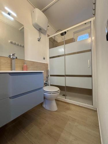 a bathroom with a toilet and a glass shower door at La Casa dei Daini in Ronciglione