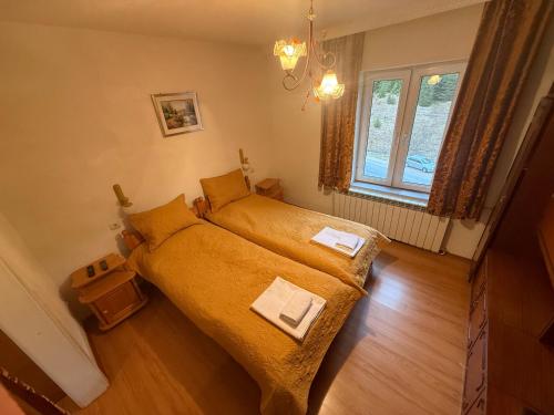 a small bedroom with a bed and a window at Къща Ники in Stoykite