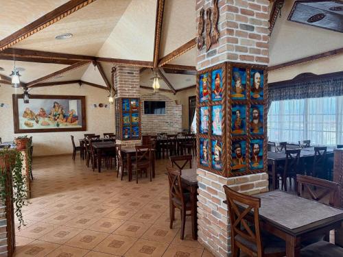 a restaurant with tables and chairs in a room at HANUL TENTEA in Săcel