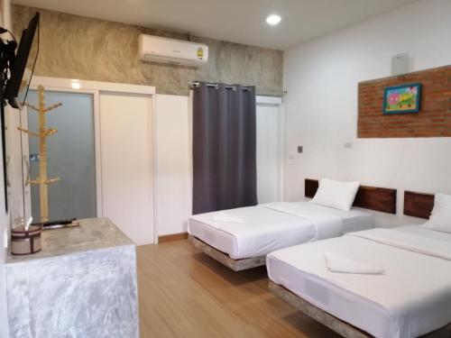 a hotel room with two beds and a window at โรงแรมเพ็ญวิวรีสอร์ท Phenview resort in Amphoe Phen