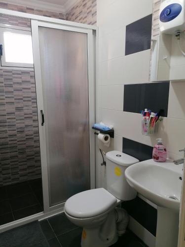 a bathroom with a shower and a toilet and a sink at Résidences nour nador in Nador