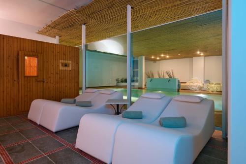 a room with four white couches and a table at Grand Hotel Bellavista Palace & Golf in Montecatini Terme