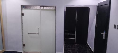 a bathroom with a shower and a glass door at Transvent Hotel And Suites in Abeokuta