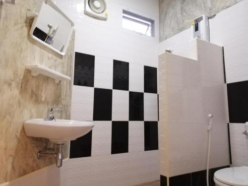 a bathroom with a black and white checkered wall at โรงแรมเพ็ญวิวรีสอร์ท Phenview resort in Amphoe Phen
