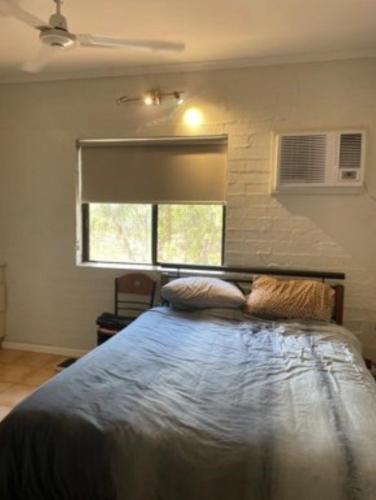 a bedroom with a bed with two pillows on it at Pearlers Lodge in Broome