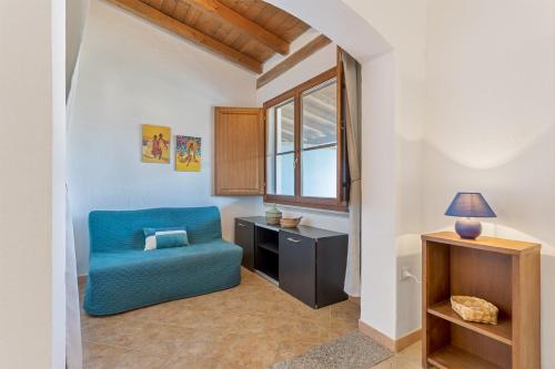 a living room with a blue chair and a desk at La Casa Azzurra in Tertenìa