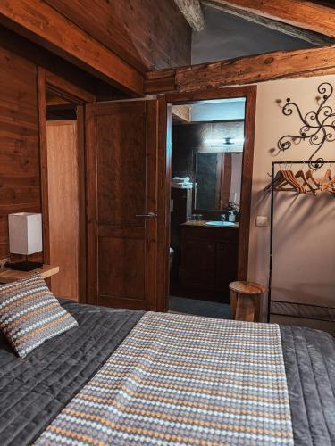 a bedroom with a bed and a bathroom with a sink at Le Mirasol Appart-hôtel in Enveitg