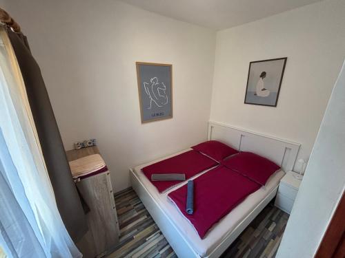a small bedroom with a bed with purple sheets at Bambusz76 in Zamárdi