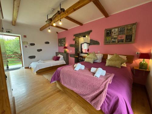 a bedroom with pink walls and a large bed at Casa do Plátano in Cinco Ribeiras
