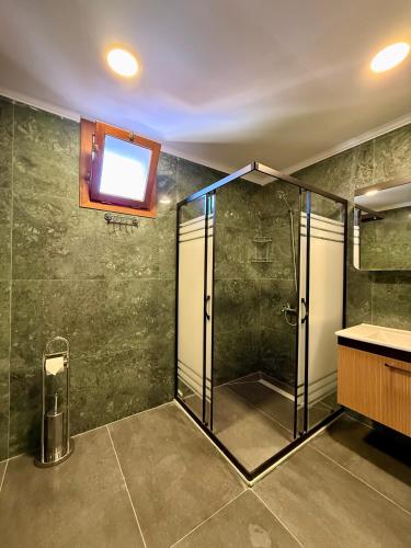 a bathroom with a shower with a sink and a window at Attalos Villa in Antalya