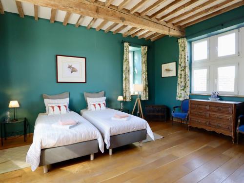 two beds in a room with blue walls at La Tour de la Chapelle in Couthuin