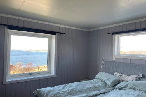 a bedroom with two windows and a bed in it at Seaview Country House in Pettvik