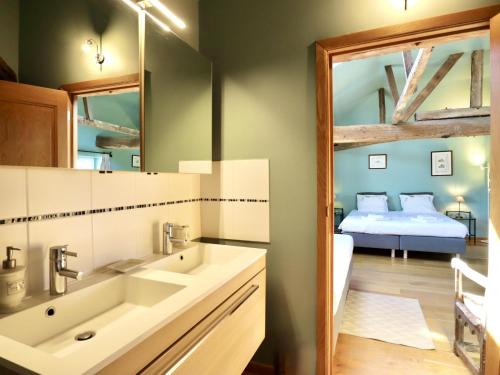 a bathroom with a sink and a mirror and a bed at La Tour de la Chapelle in Couthuin