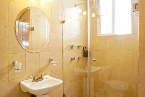 a bathroom with a sink and a shower with a mirror at Hotel GranMadero in Durango