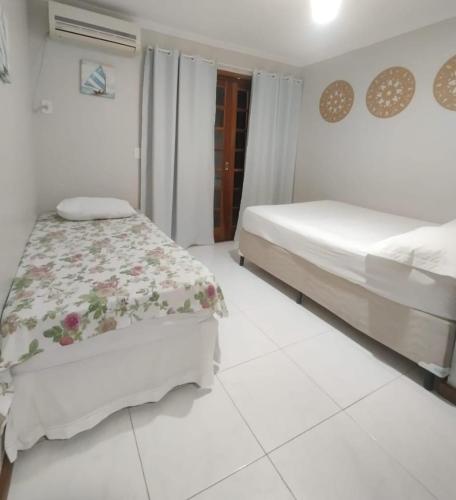 a bedroom with two beds and a white tiled floor at Recanto Vista Mar - Costa Verde, Mangaratiba in Mangaratiba
