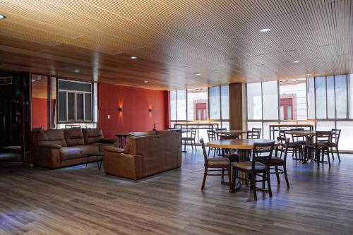 a large room with tables and chairs and windows at Hotel GranMadero in Durango