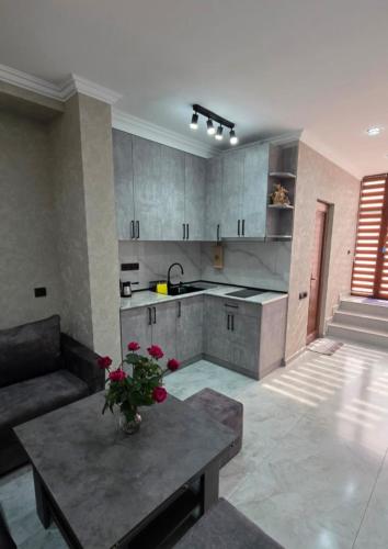 a kitchen and living room with a table and a couch at Livana Guesthouse - Goris in Goris