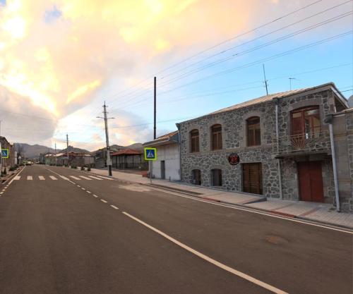 an empty street in a town with a stone building at Livana Guesthouse - Goris in Goris