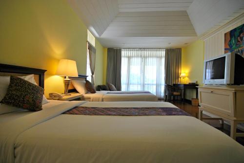 a hotel room with two beds and a television at Baan Bayan - Hua Hin - SHA Extra Plus in Hua Hin