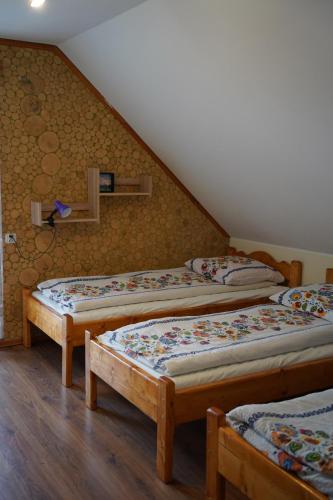 three beds in a room with a attic at Domek u Johnnego 28 in Piwniczna Zdrój