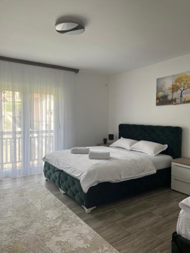 a bedroom with a large bed and a window at Apartmani Zeleni Horizont in Bratunac