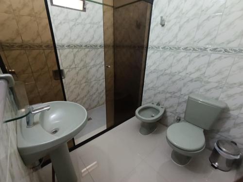 a bathroom with a sink and a toilet and a shower at Hotel Sancer in Coronel Oviedo