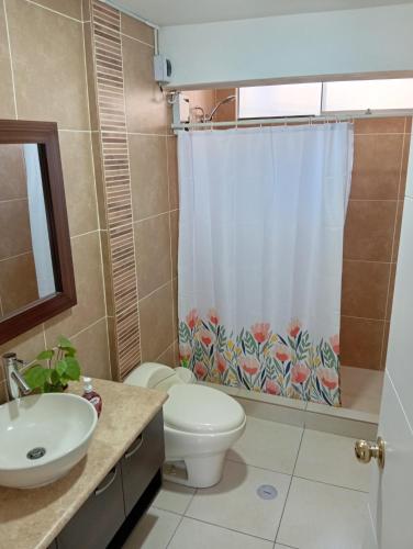 a bathroom with a toilet and a shower curtain at villa hermosa cayma in Yanahuara