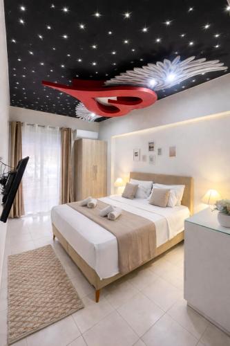 a bedroom with a large bed with a red airplane on the ceiling at Rhodes Nest in Ixia