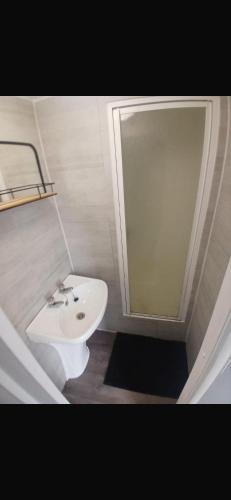 a bathroom with a white sink and a shower at Y29 golden anchor in Chapel Saint Leonards