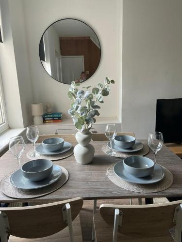 a dining room table with plates and a mirror at Petal House, Gloucester - Large, Spacious and charming in Gloucestershire