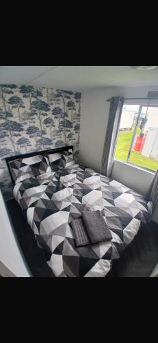 a bedroom with a black and white bed with a window at Y29 golden anchor in Chapel Saint Leonards