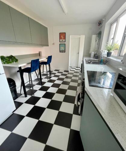 a kitchen with a black and white checkered floor at Petal House, Gloucester - Large, Spacious and charming in Gloucestershire