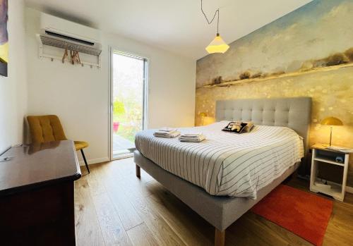 a bedroom with a bed and a desk and a window at LA PATTE D'OURS 2 in Ambon