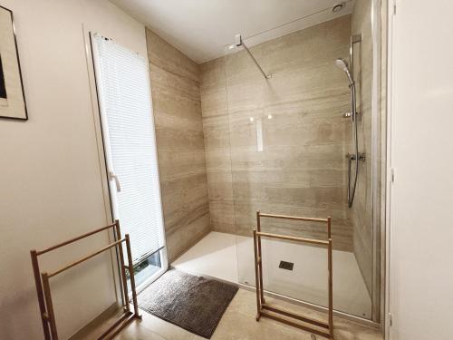 a shower with a glass door in a bathroom at LA PATTE D'OURS 2 in Ambon