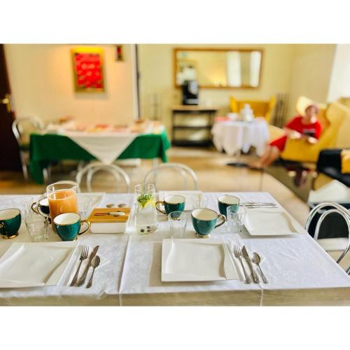 a table with plates and utensils on top of it at Hotel pod Dębem in Szydłowiec