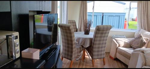 a living room with a table and chairs and a couch at Y29 golden anchor in Chapel Saint Leonards