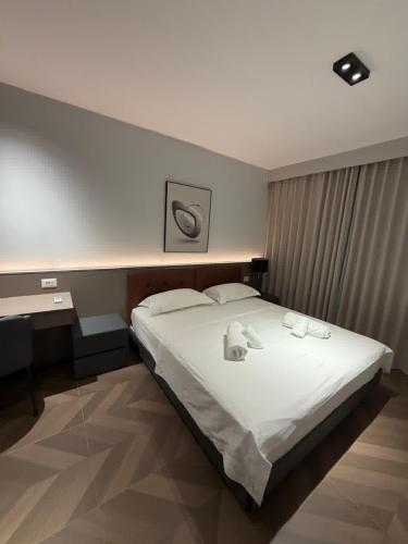 a bedroom with a large bed with towels on it at Casa Del Sol - Shengjin in Shëngjin
