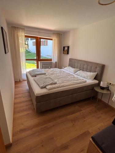 a large bed in a bedroom with a large window at Ferienwohnung Steibis / Allgäu in Steibis