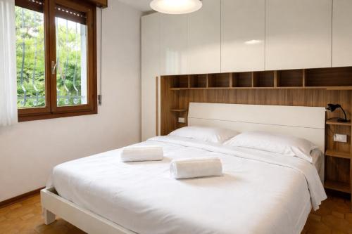 a large white bed with two white pillows on it at Villa Riviera by the Sea in Lignano Sabbiadoro