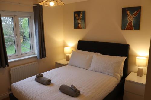 a bedroom with a bed with two stuffed animals on it at 3 Bed Home, Exeter, Devon in Countess Wear