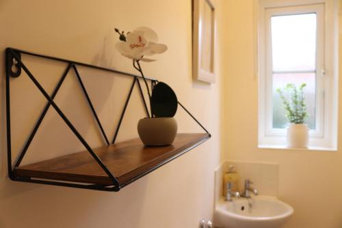 a bathroom with a wooden shelf above a sink at 3 Bed Home, Exeter, Devon in Countess Wear