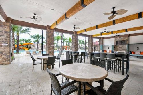 a patio with tables and chairs and a kitchen at 6 Bedrooms 5.5 Bathrooms Solterra 4193 OD in Orlando