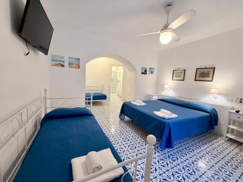 a bedroom with two beds and a flat screen tv at La Casa al Mare Vulcano in Vulcano