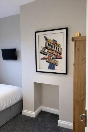 a room with a bed and a picture on the wall at Bed for the night, Close to Beach, Shops , Train in St. Leonards