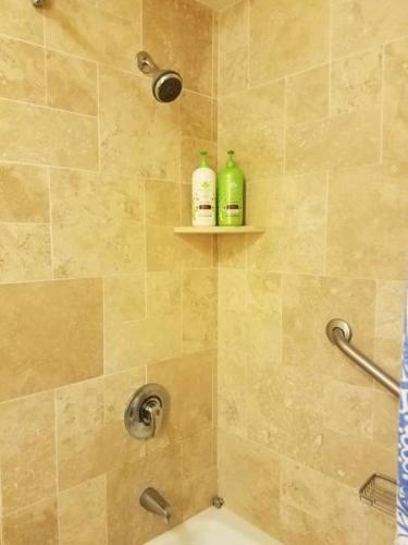 a bathroom with a shower with two shampoo bottles at 2417 at Oceanfront Resort Lihue Kauai Beach Drive Private Condo in Lihue