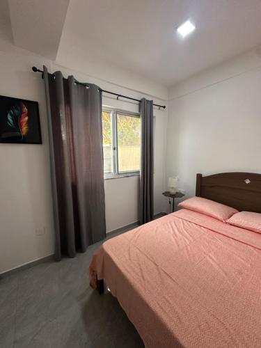 a bedroom with a bed and a window at Quarto individual- Espaço Casa Mendes in Praia
